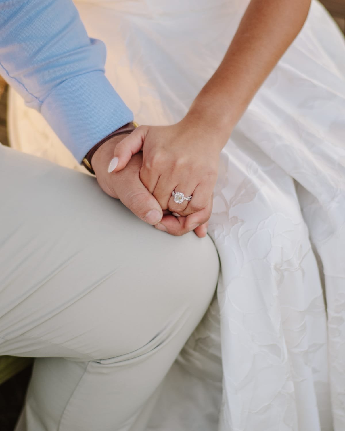 Their hands clasped together, Katherine's engagement ring in close view.